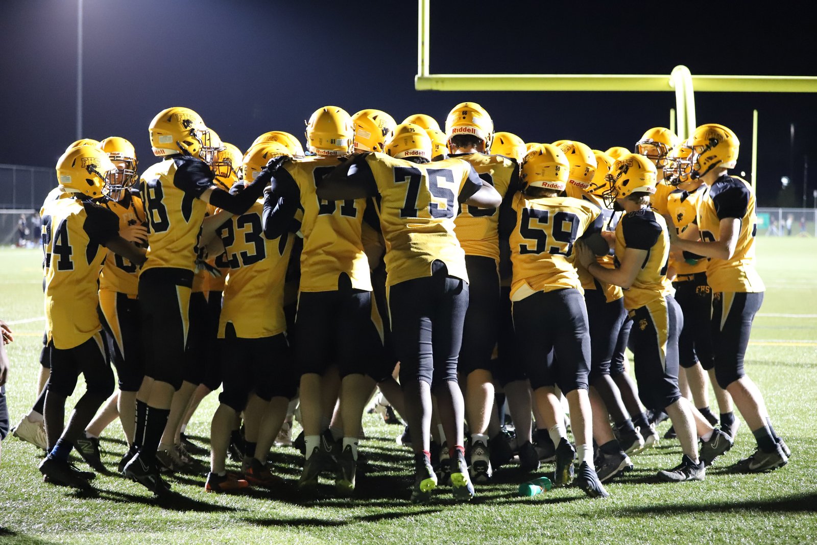 The Black Kats huddle on the field before a game
